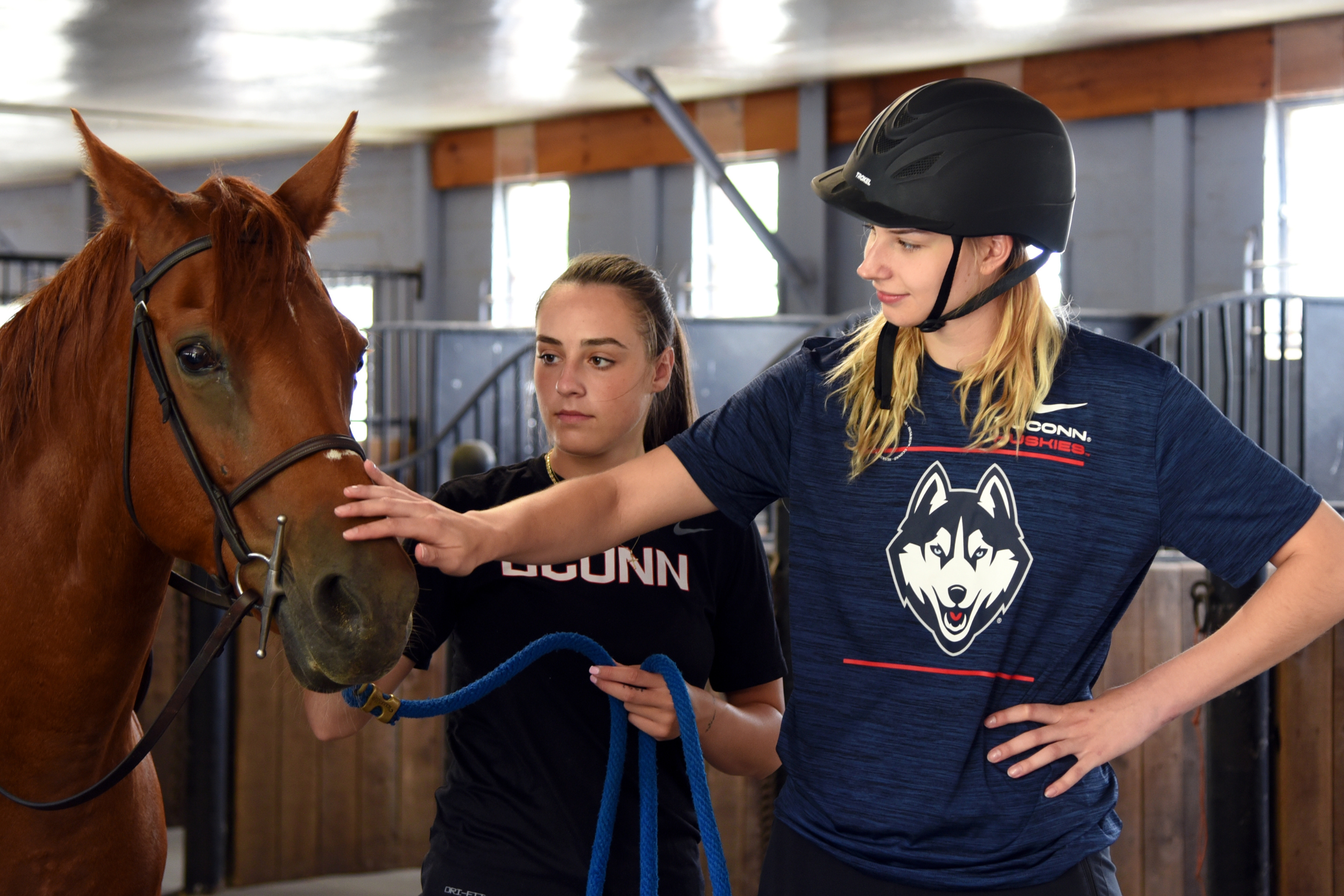 Students petting their horse inside of Horse Unit I