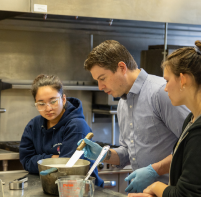 Dr. Dennis D'Amico instructing student during a cheese making lab in the Jones Building