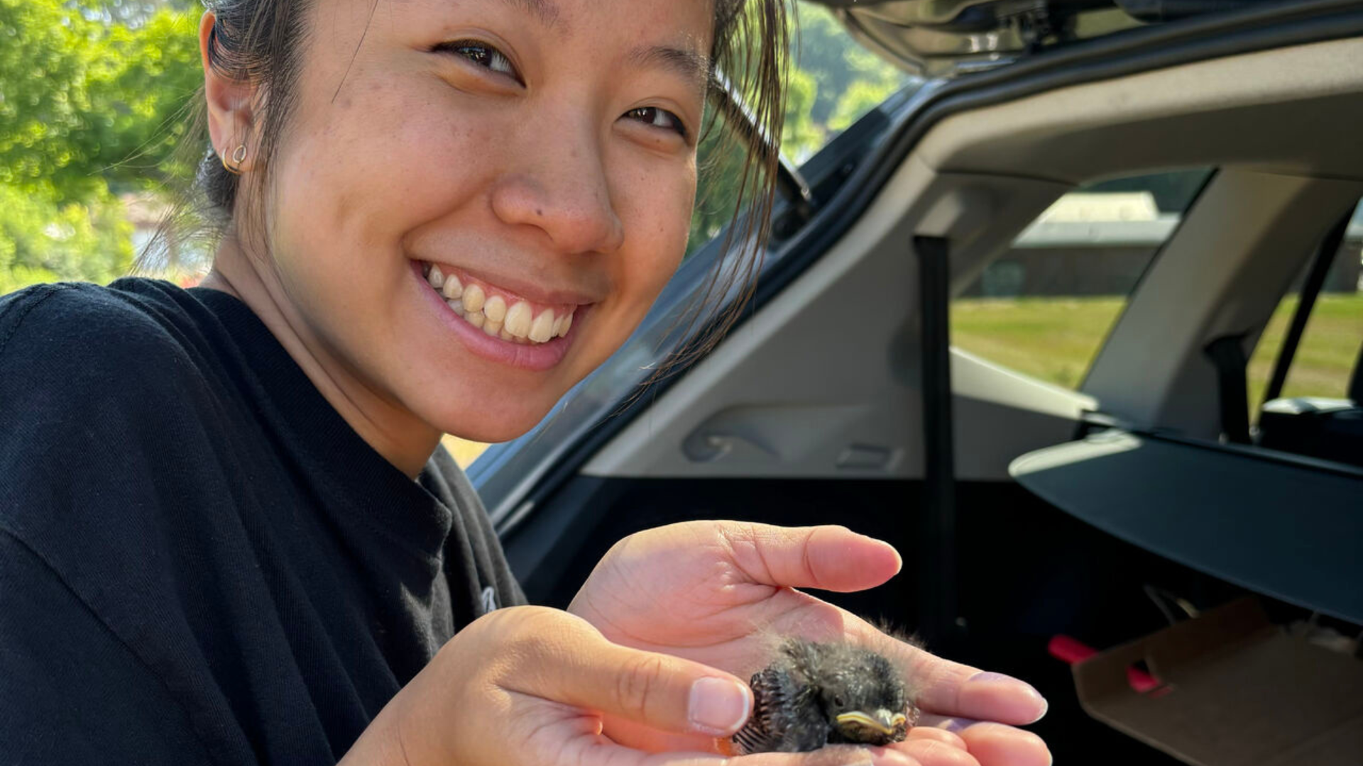 Carissa Leung posing for a photo while holding a baby bird.