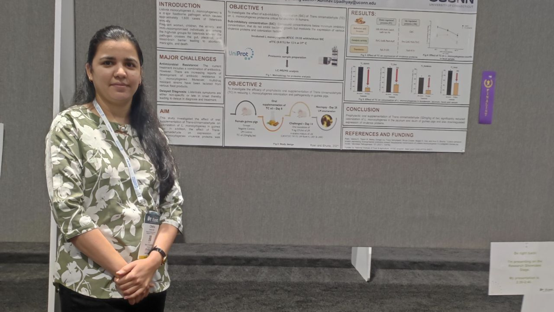 Chetna Shah posing for a photo in front of her research poster. 