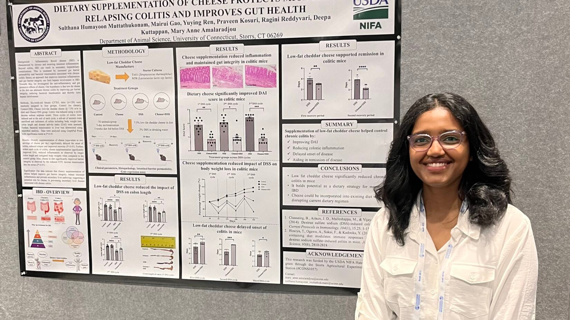 Sulthana Humayoon Muttathukonam posing for a photo in front of her research poster.